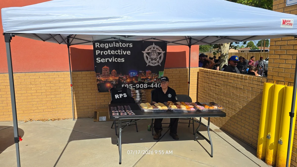 Regulators banner and a representative at a community event booth in July 2026.